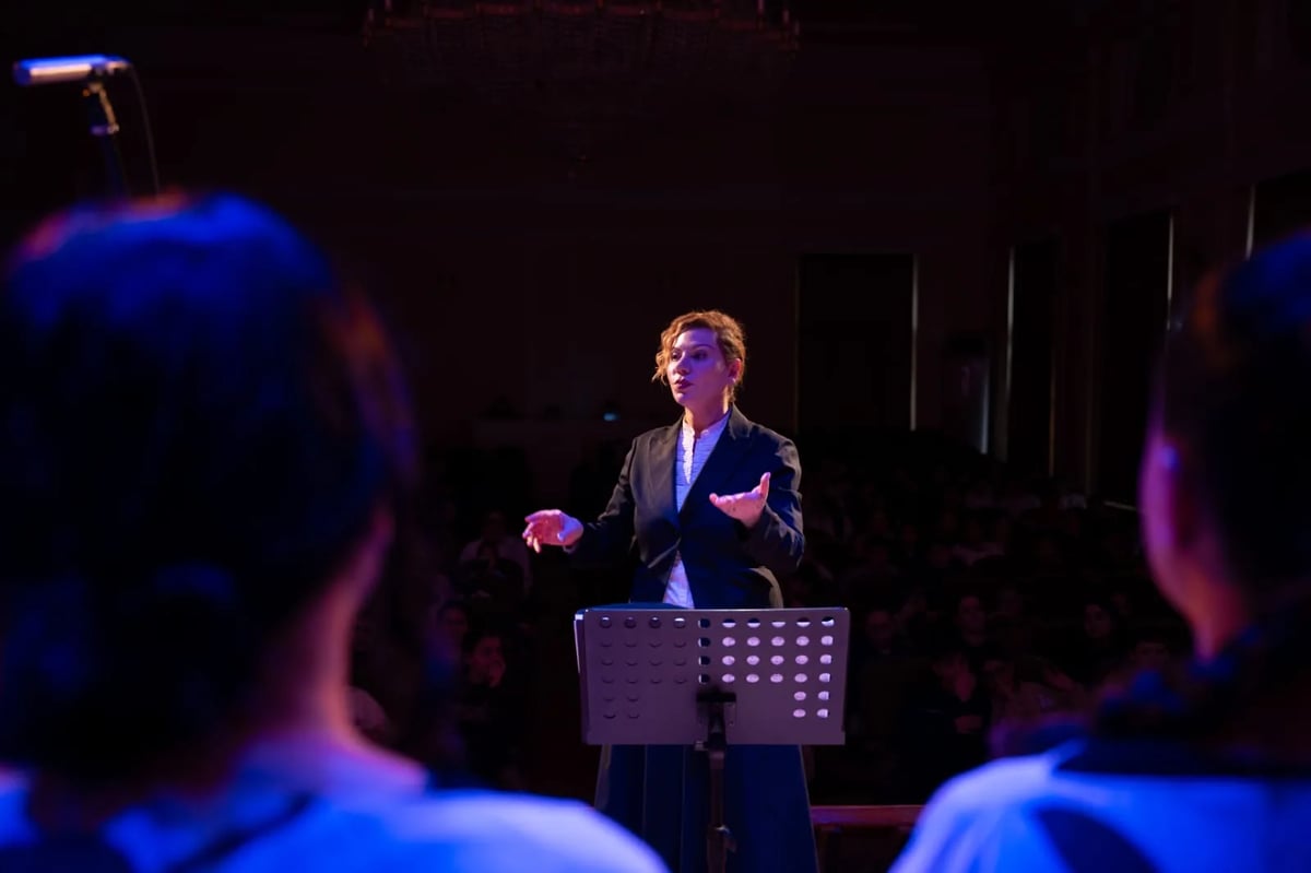 Hasmik Vardanyan conducting Yerevan Voices on a spotlighted stage
