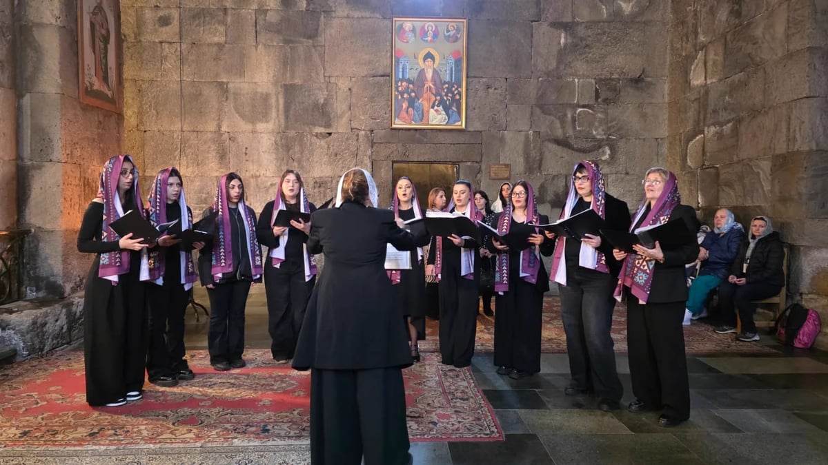 The choir singing in embroidered veils inside a medieval Armenian church